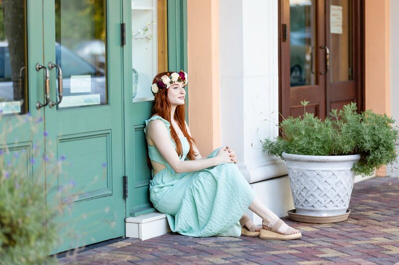 Beautiful young woman sitting on a storefront stoop in Downtown Sarasota taken by Love and Style Photography