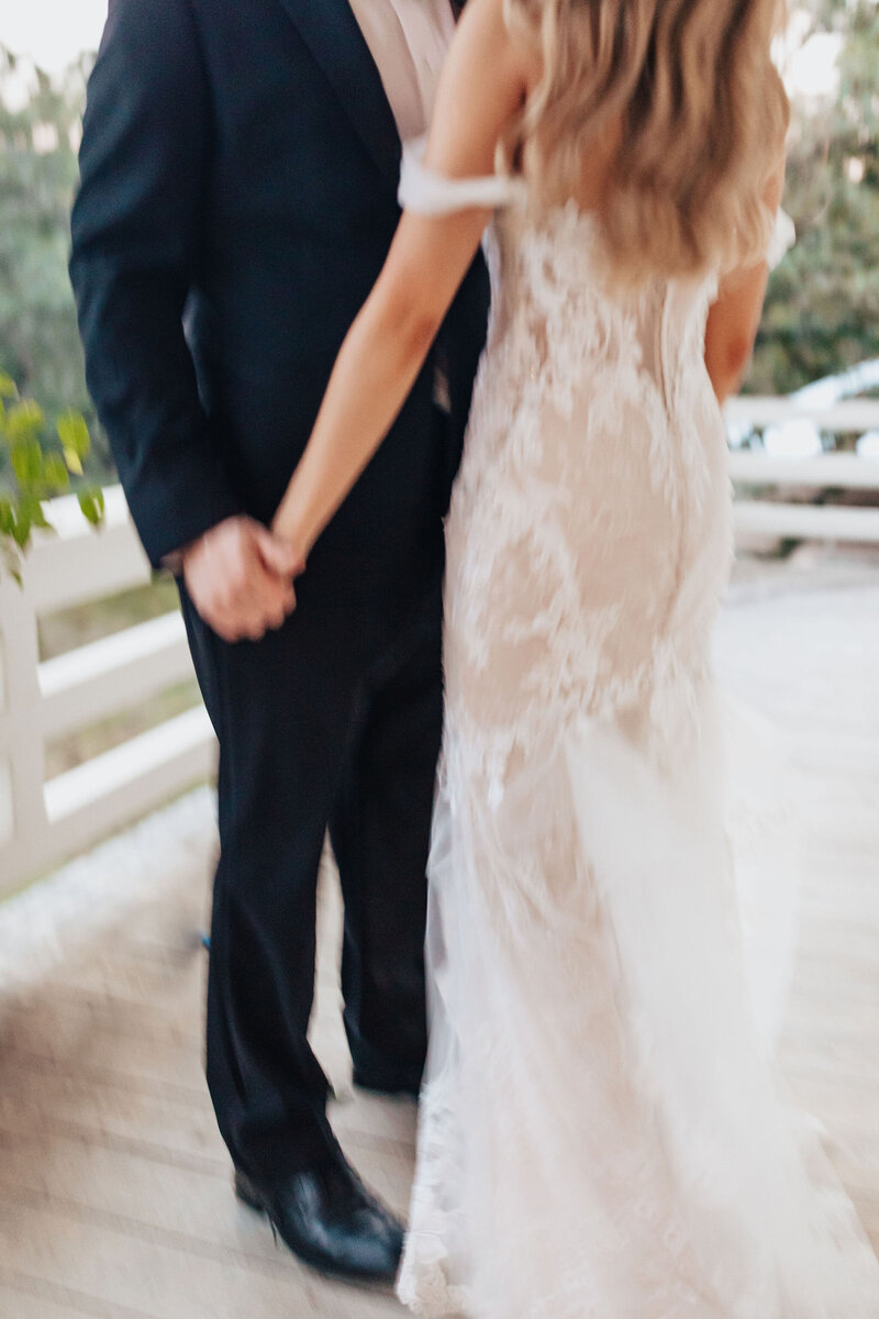 blurred photo of bride and groom holding hands