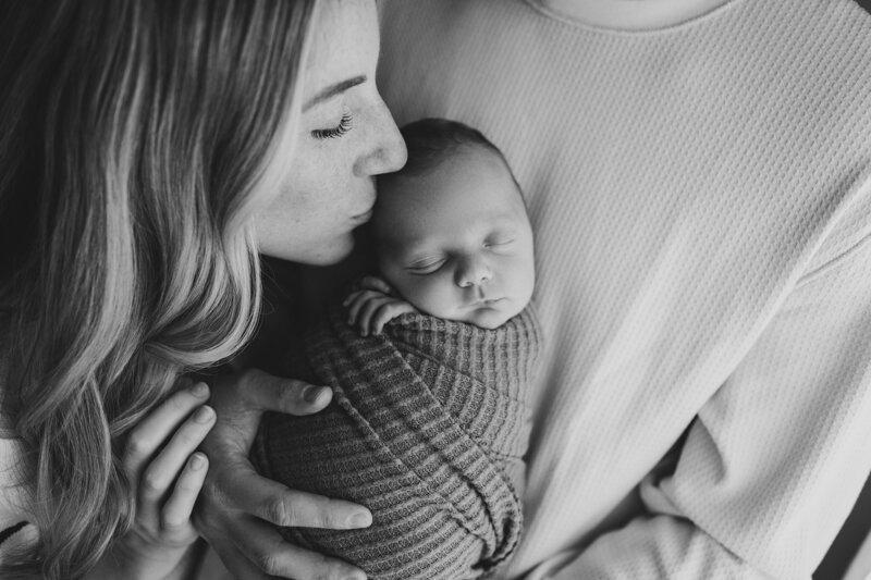 new mom kissing newborn baby