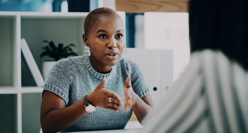 Engaged manager sharing insights during a one-on-one, reflecting applied leadership and communication skills.