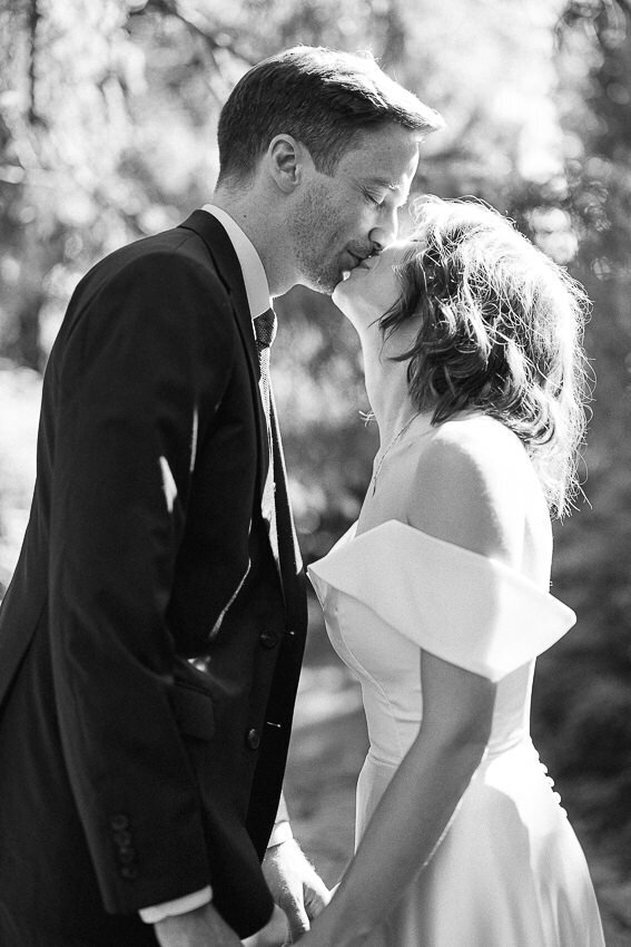 Un couple s'embrasse sous le soleil en plein nature. Mariage au Parc Jean Drapeau.