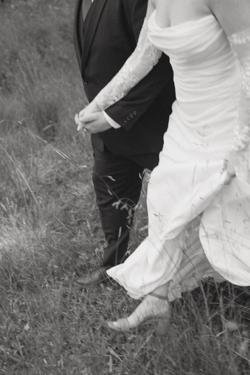 A couple holding hand and running through a meadow in Telluride, Colorado