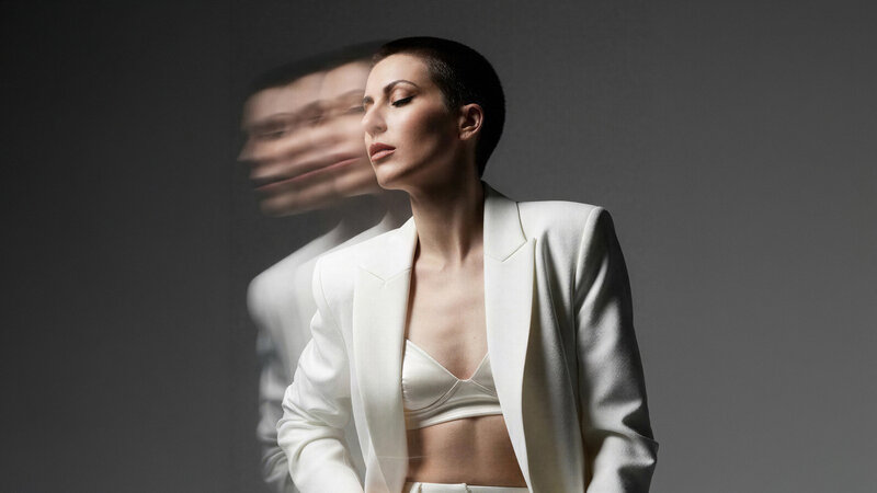 Jasmina Kimova in a white tailored suit with a motion-blur effect, representing cinematic storytelling and high-impact personal reinvention.