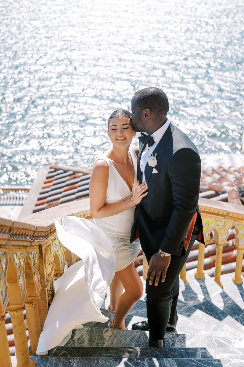 Bride and groom standing together by the ocean