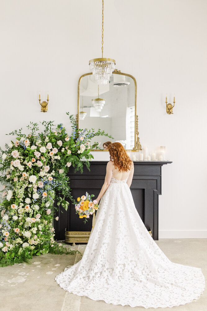 bride in a white wedding dress standing in front of a black fireplace
