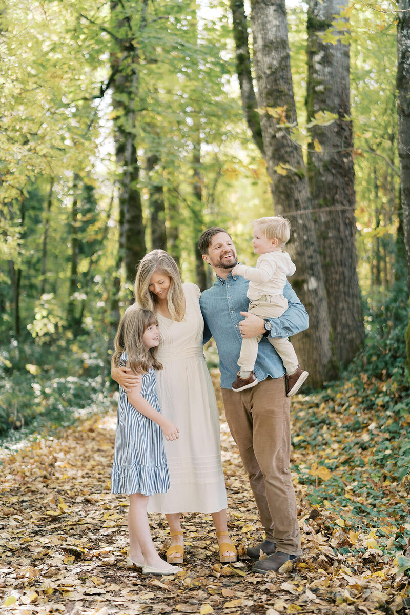 family of four in fall forest near portland oregon for family photos