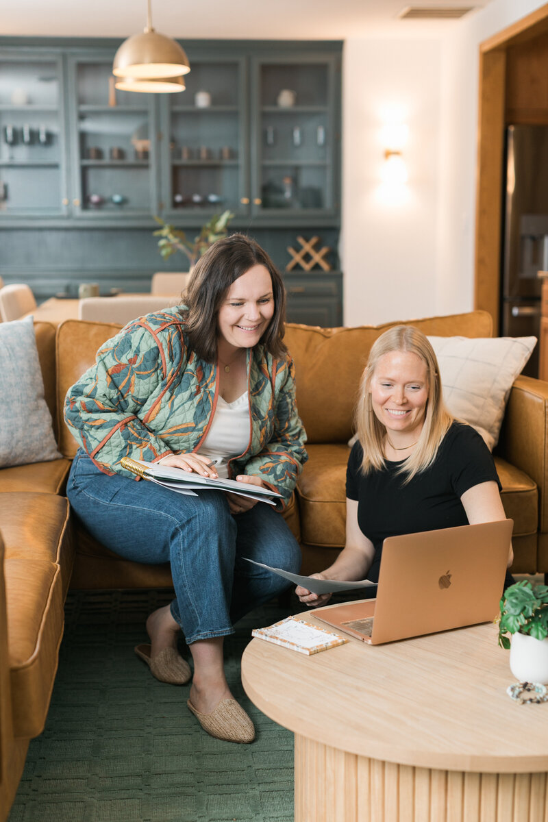 two women working at a laptop