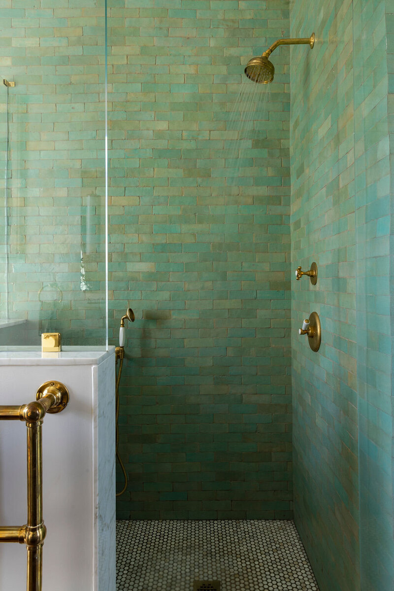 Green tiled shower with gold finishes