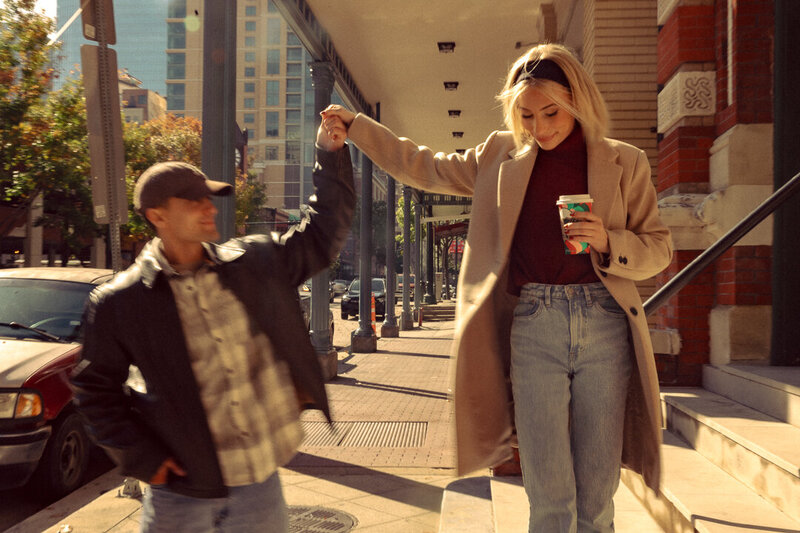 Engagement photos for a young couple on a coffee date in the city streets of downtown Housotn, Texas in December.