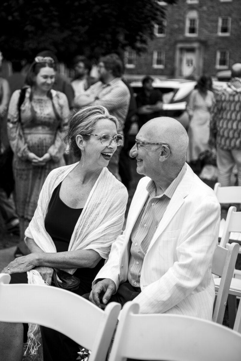Parents looking joyful during outdoor wedding ceremony.