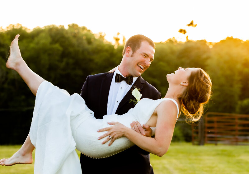 Maryland Farm Wedding in Howard County, Groom holding the bride during sunset as couple laughs