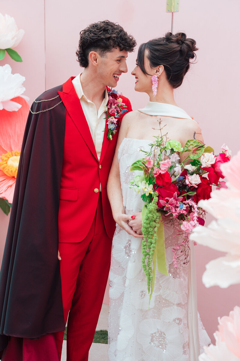 Bride and groom with pastel floral background.