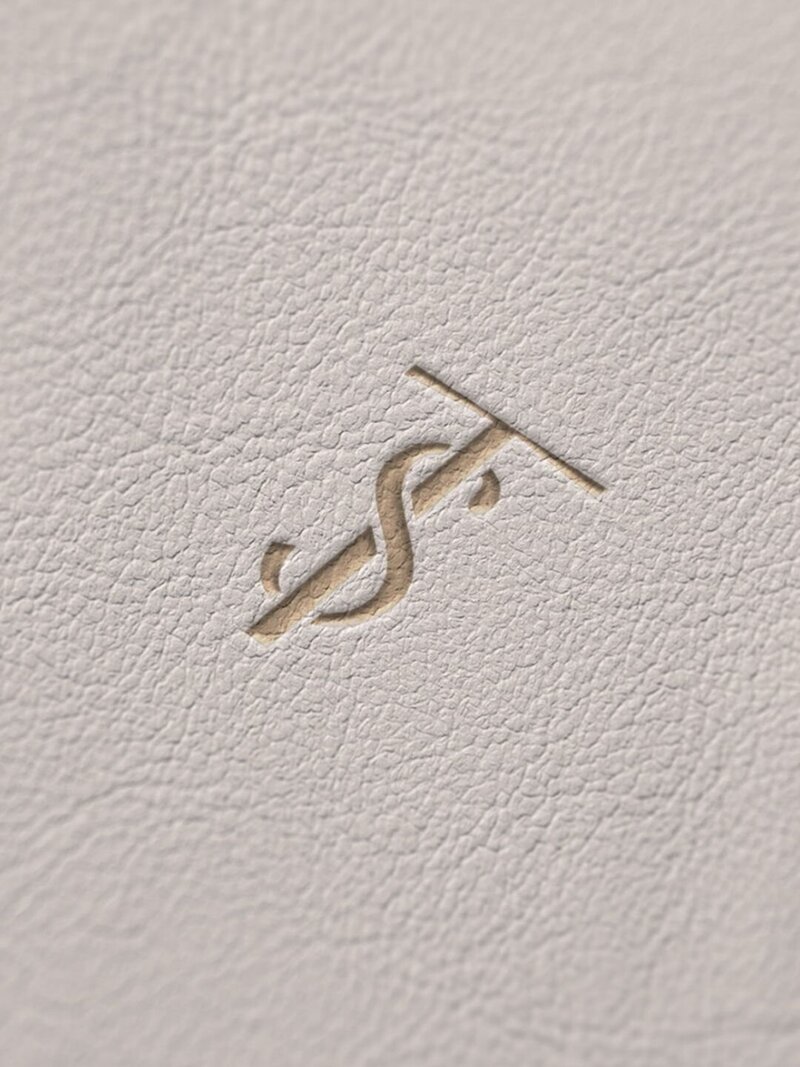 Toska Spa monogram embossed into neutral leather texture, showcasing luxury brand detail