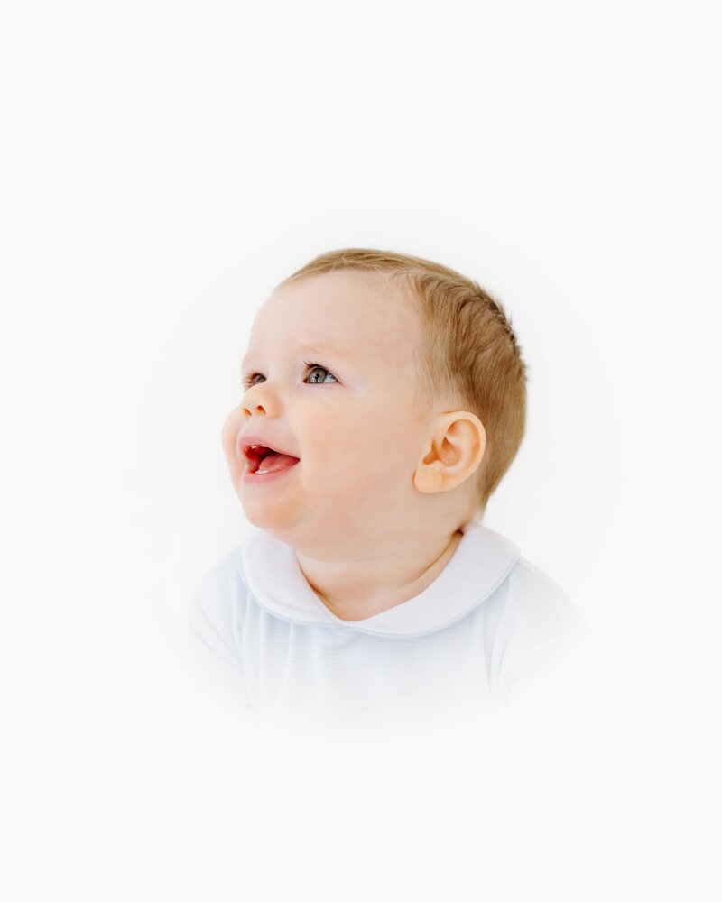 Smiling child in heirloom session wearing neutral outfit – OKC children’s fine art portrait
