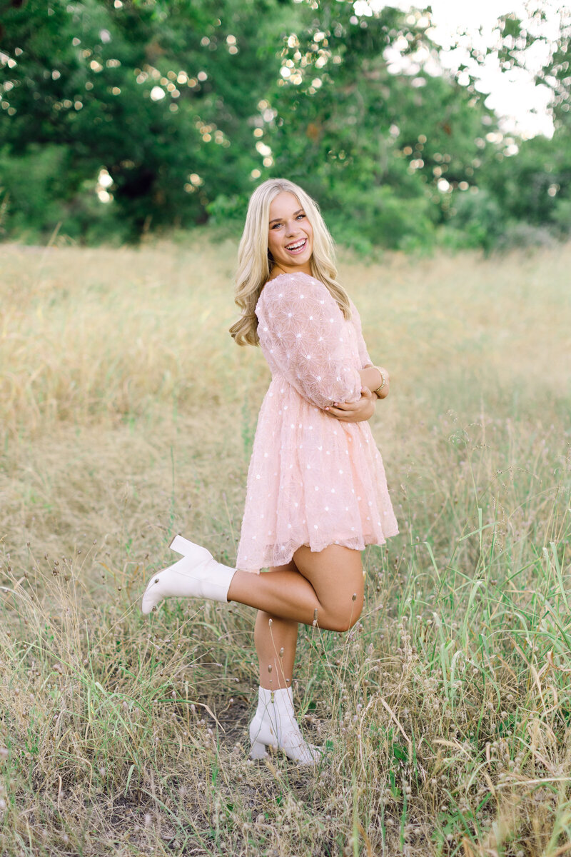 Cute pose of senior girl in pink dress in field at sunset in Malibu, CA
