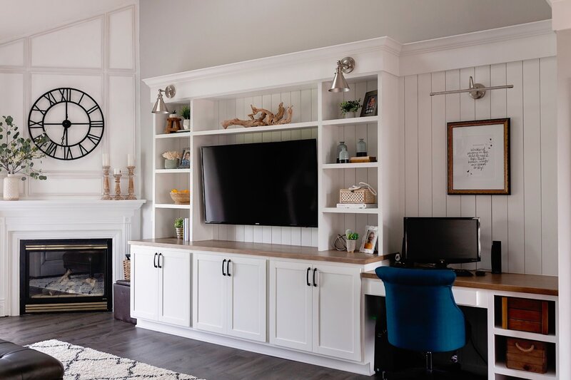 Living room design with white cabinets and a a leather ottoman.