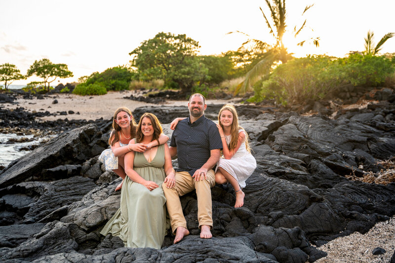 Sitting on lava rocks for family photos on the big island by Hawaii Adventure Portraits