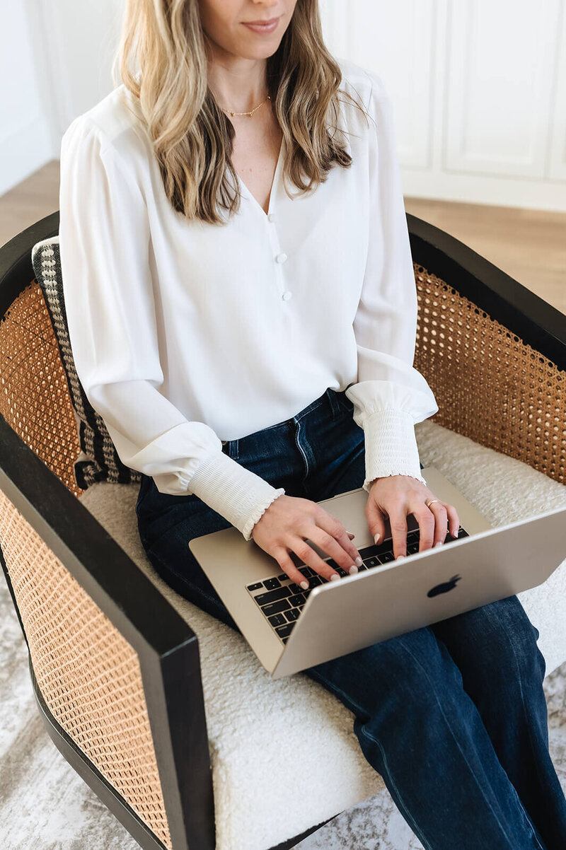 Woman typing on laptop to sign up for Erica Taylor Wellness weekly newsletter with simple wellness tips for moms