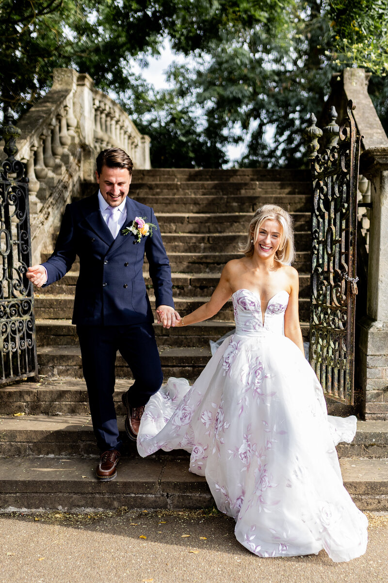 Bride and groom walking down grand stairs