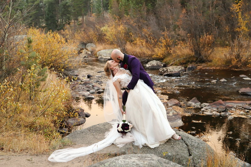 Couple on their wedding day who are kissing by the water in Colorado