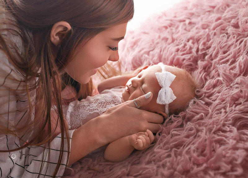 sleeping baby posing in flowy bunny hat in blush wrap swing