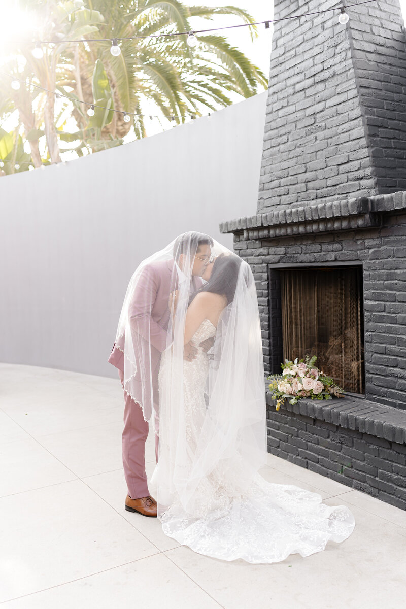 Orange County Wedding Photographer captures romantic newlyweds around the fireplace at the Colony House