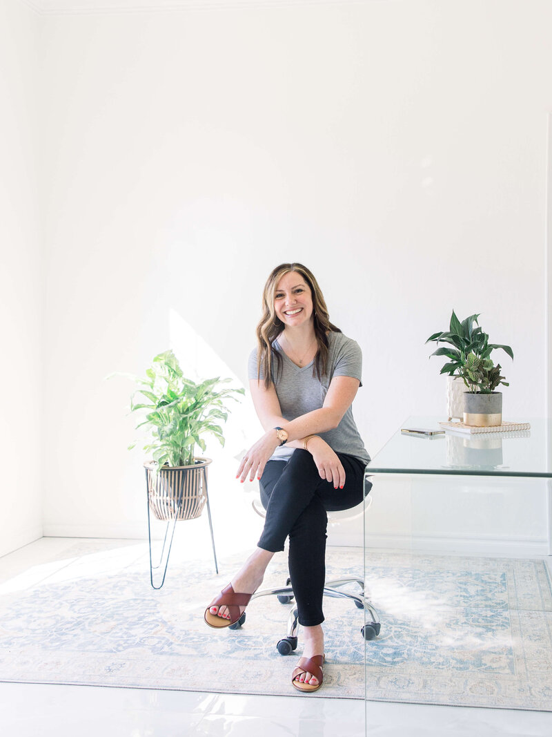 woman in comfy close sitting at a glass desk