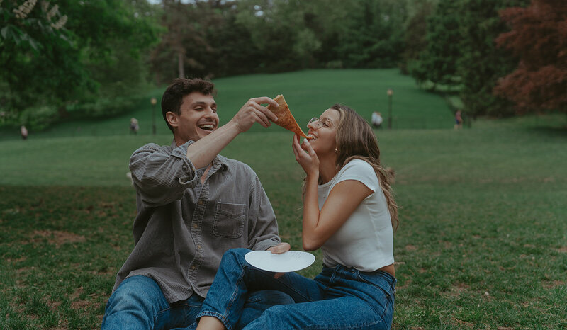 couple eating pizza in prospect park during nyc engagement photos, captured by Elsie Goodman, an NYC engagement and couples photographer