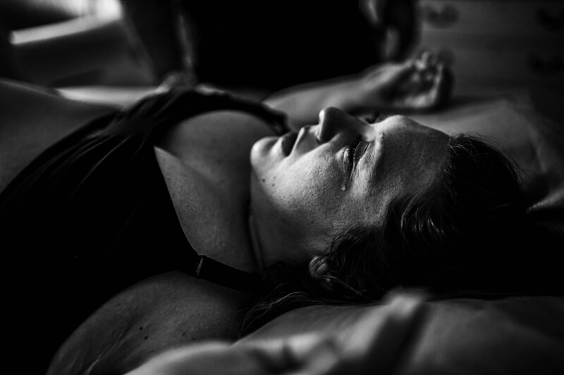 Mother laboring in black and white, eyes closed as she breathes through a contraction — raw birth moment captured by a Fort Worth birth photographer.”