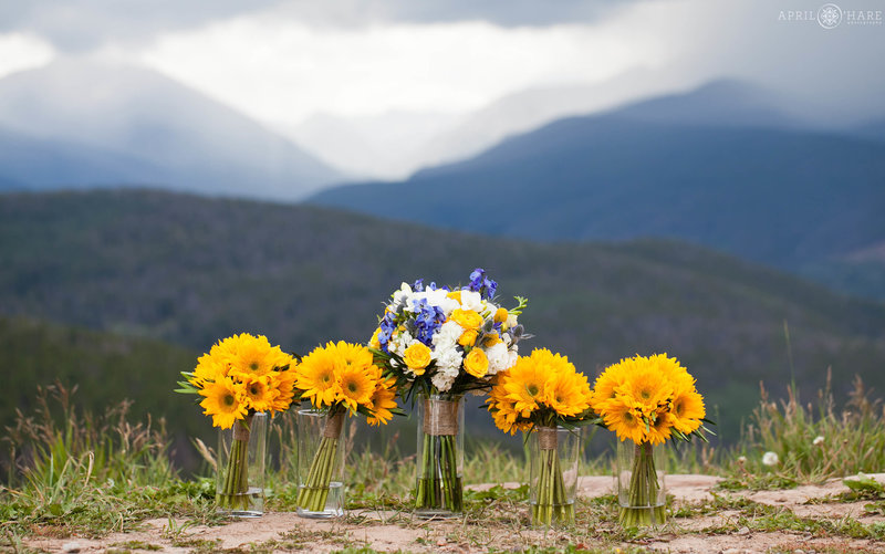 Pretty Bright Yellow Sunflower bouquets with mountain backdrop behind them at the Vail wedding deck in Colorado