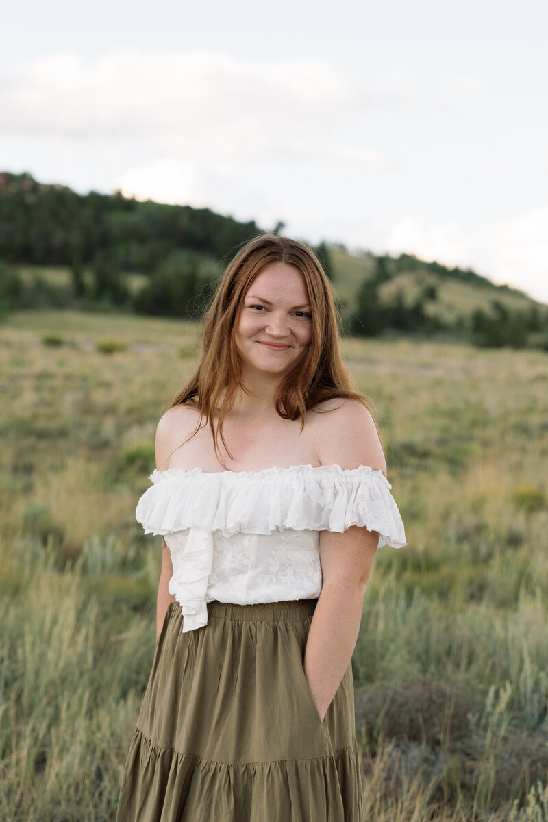 Woman looking at the camera in a field in Colorado. 