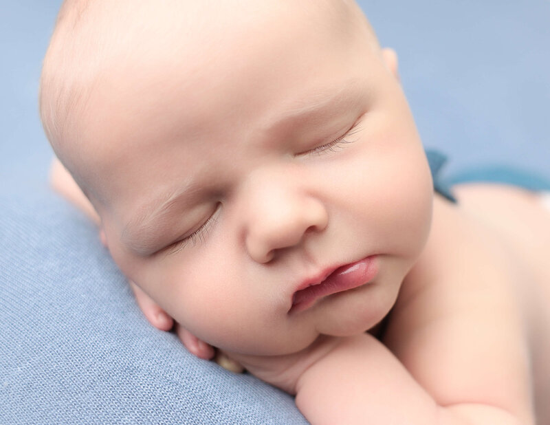 Sleeping newborn boy posed  in our Rochester NY studio.