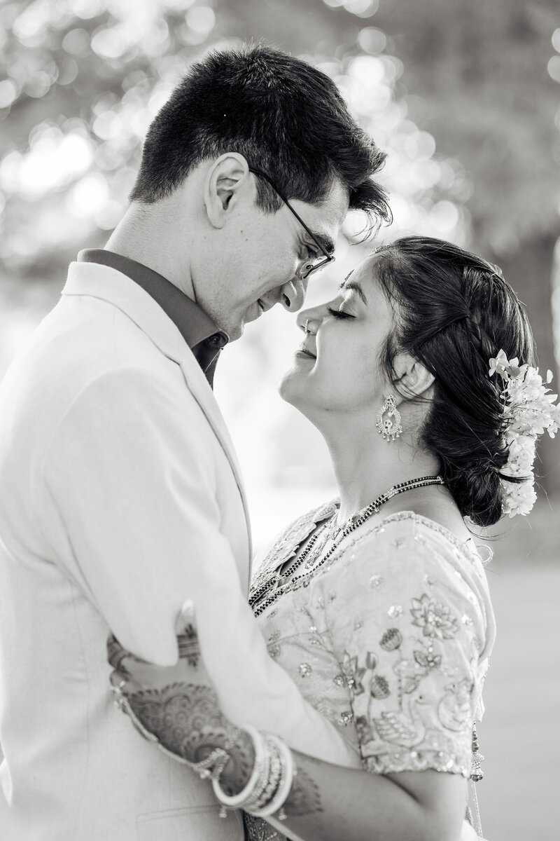 bride and groom stand face to face in black and white portrait at the Meadows in Raleigh