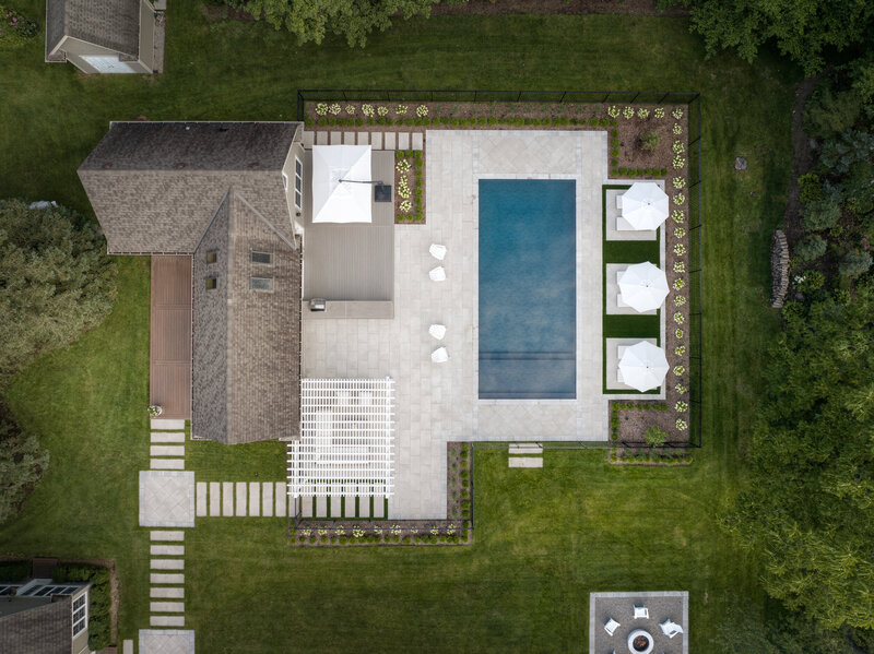 birds eye vie view of a modern backyard deck with a pergola and a rectangular pool