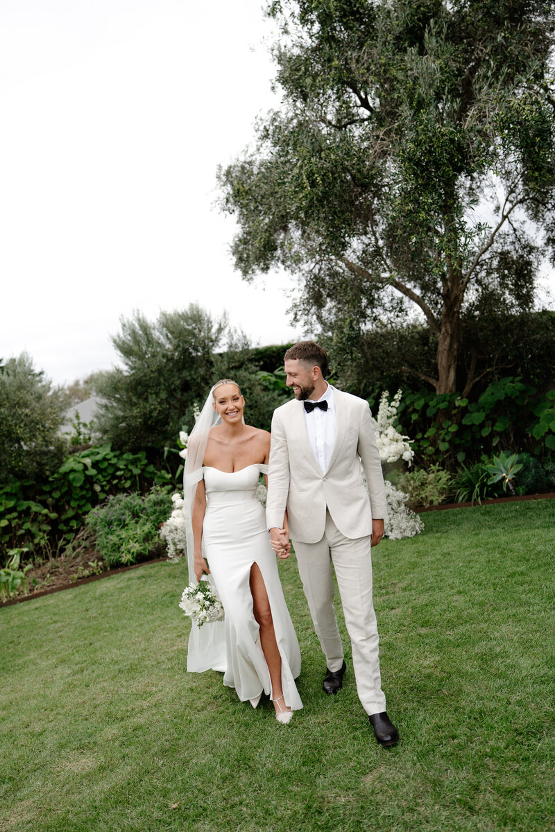 bride with bow on dress walking up stairs with husband