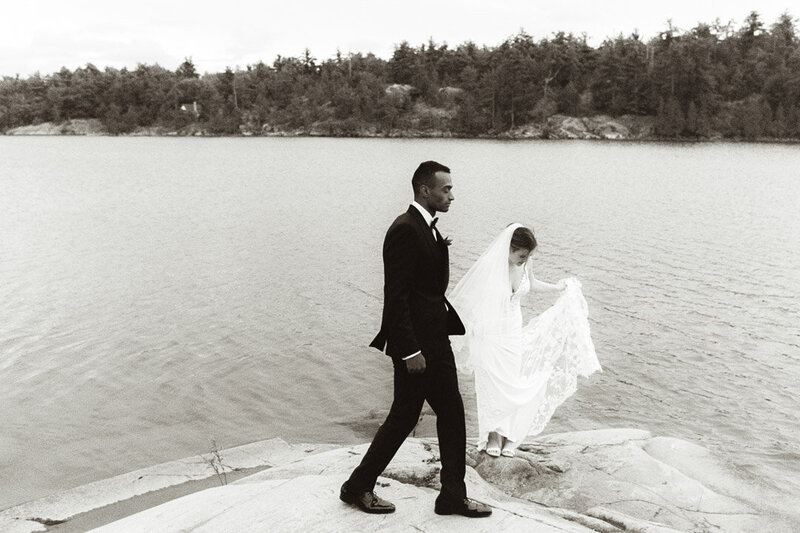A bride and groom walking by the water documented by a Sudbury Documentary Photographer