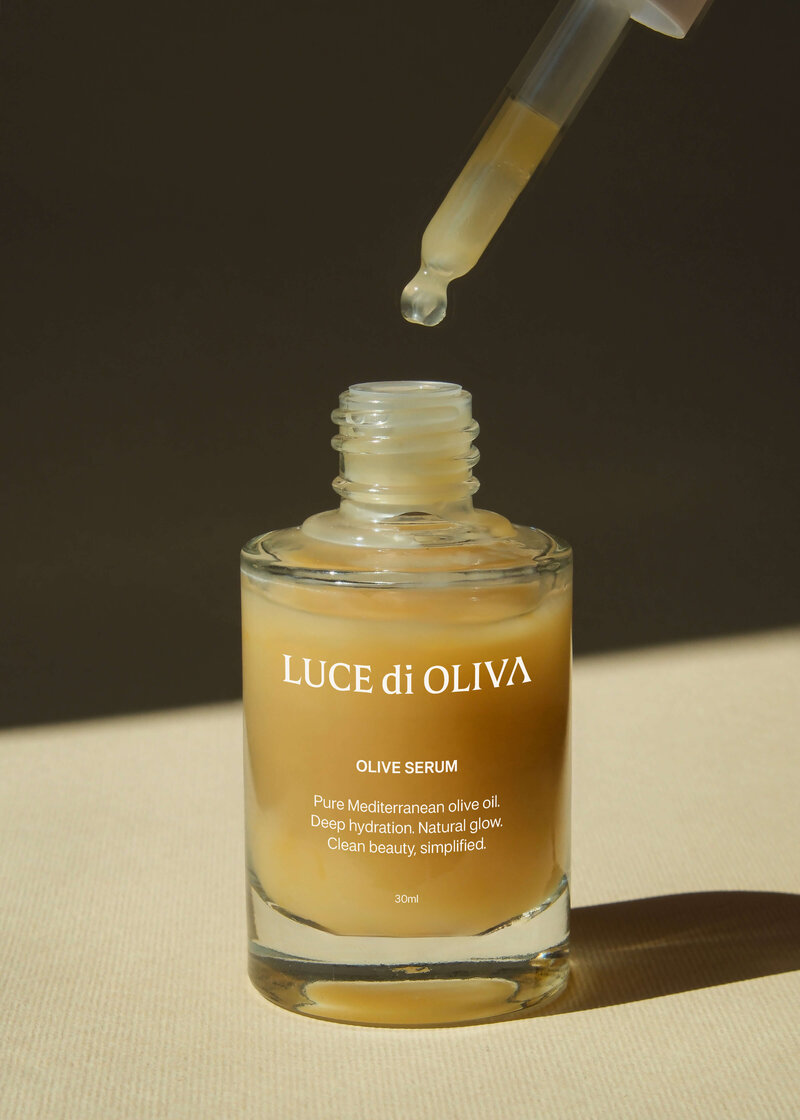 Luxury olive serum bottle with dropper showing golden Mediterranean olive oil skincare product designed by Studio Stoked