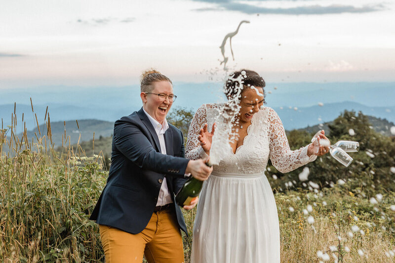 Couple celebrating their Asheville elopement with a champagne pop.