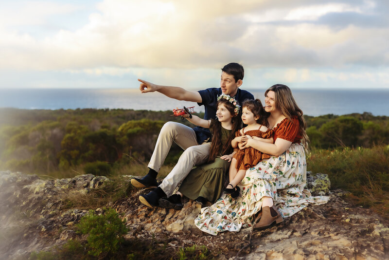 A family enjoying a photography session together on a mountaintop on the Sunshine Coast, capturing joyful and connected moments in nature.