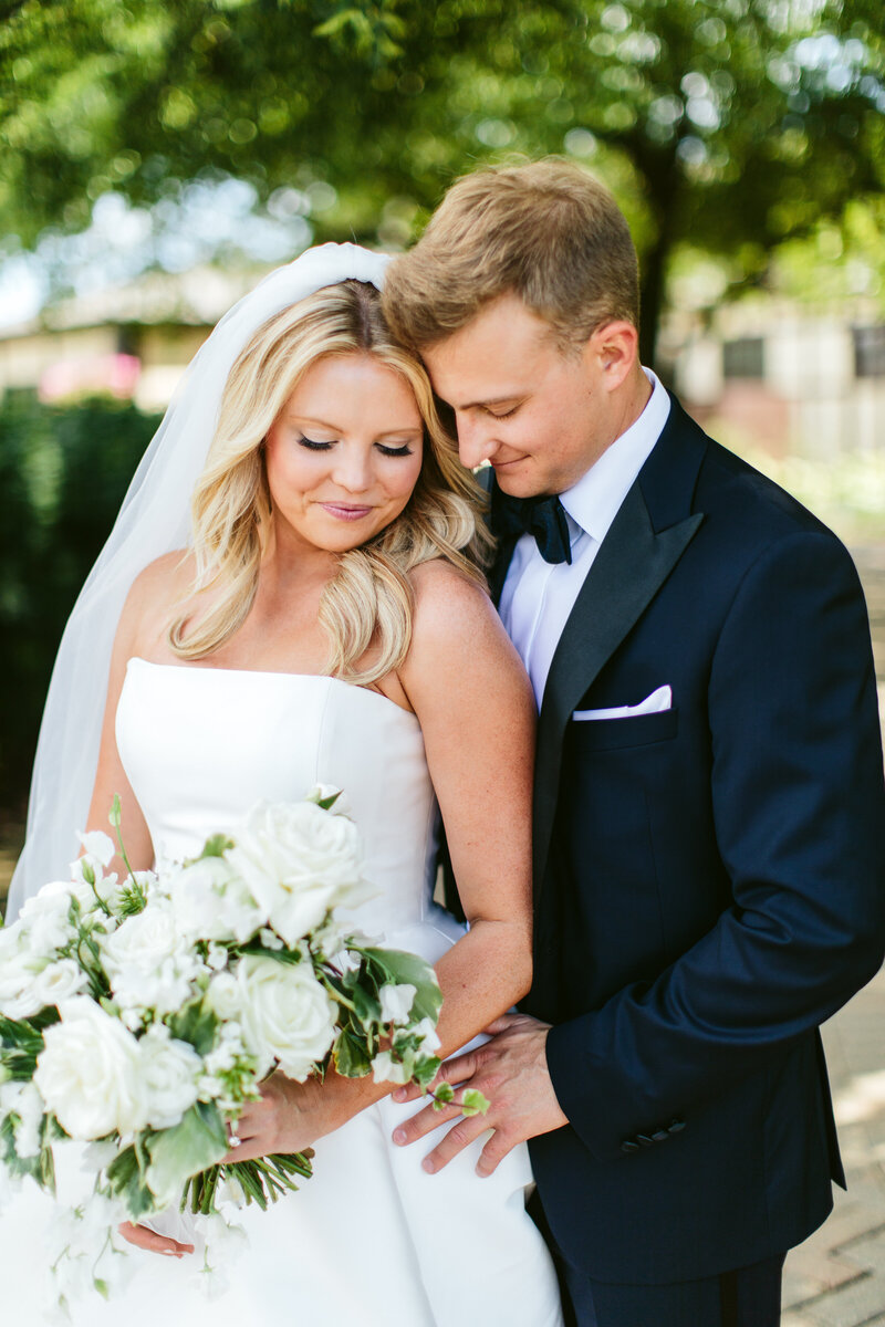 Bride and groom with white and pink bouquet.