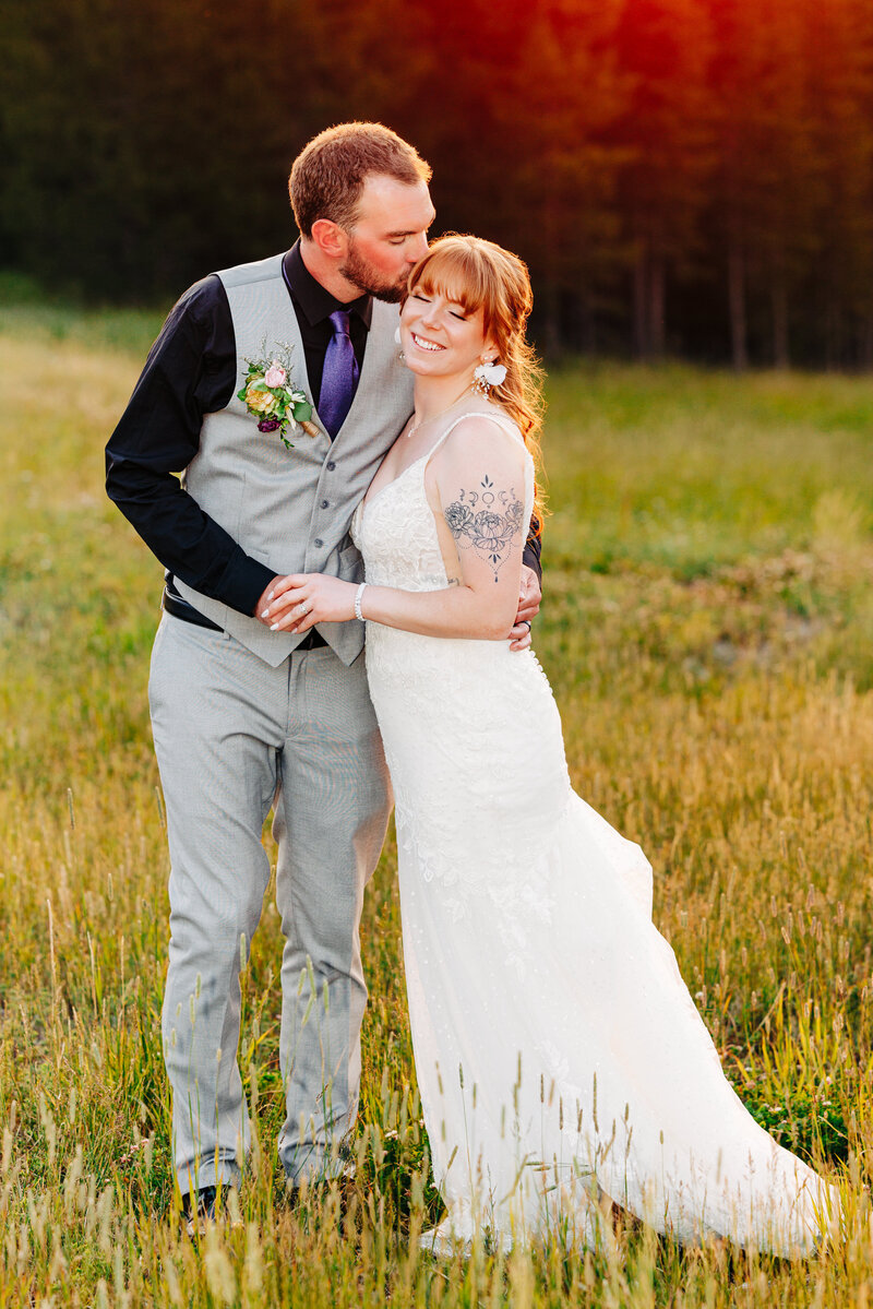 Sunset portrait of groom kissing bride at Big Sky Resort in Big Sky, MT