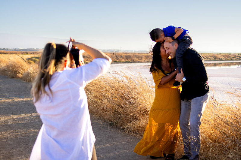 Bay Area Lifestyle Photographer - Ellobelle Photography Family Photographer smiles while photographing nature in warm golden sunlight