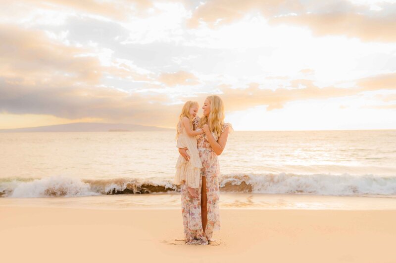 mother and daughter play on a wailea beach wearing beautiful sun dresses