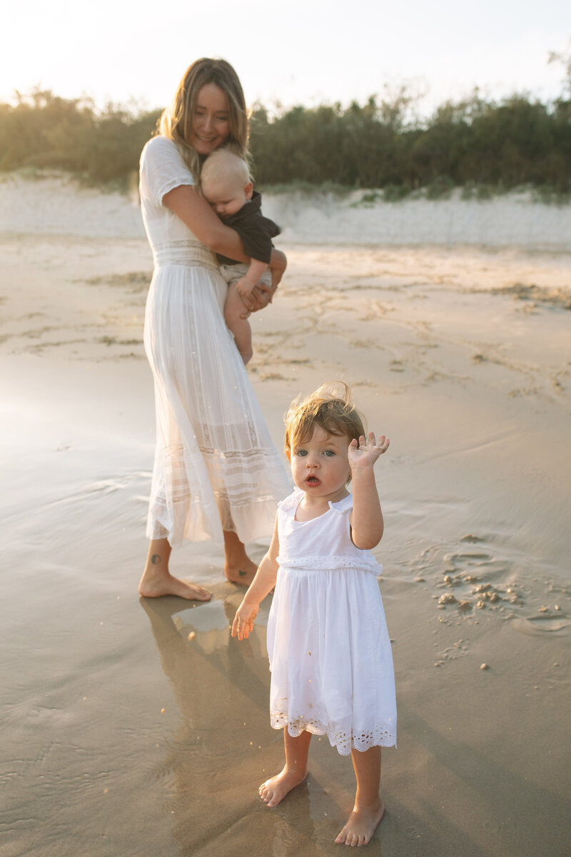 Mother and child dressed in white on Dreamtime Beach in the Nortthern Rivers. Cute toddler photo in golden sunset light