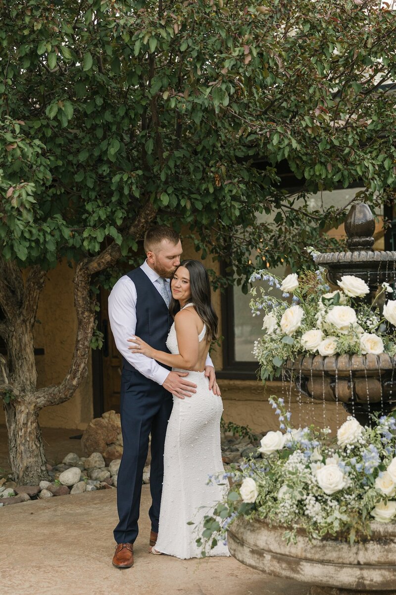 Bride and groom embracing by the courtyard fountain at Villa Parker — European-inspired Colorado wedding venue photography.