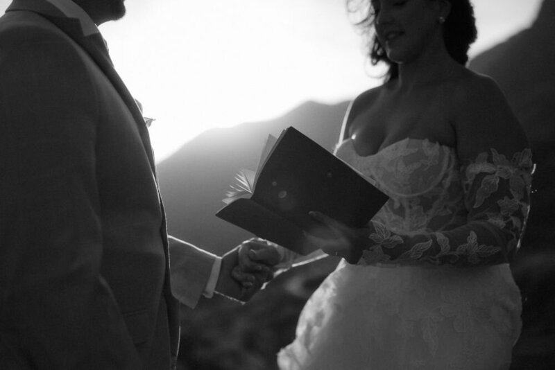 A bride and groom hold hands while sharing their vows at the top of a mountain in Glencoe, Scotland