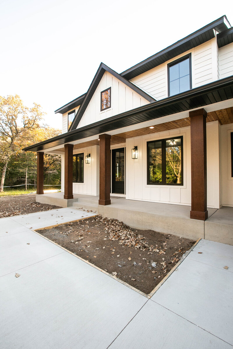 Custom Minnesota Home built by Cornerstone Custom Builds with cream siding and dark wood pillars.