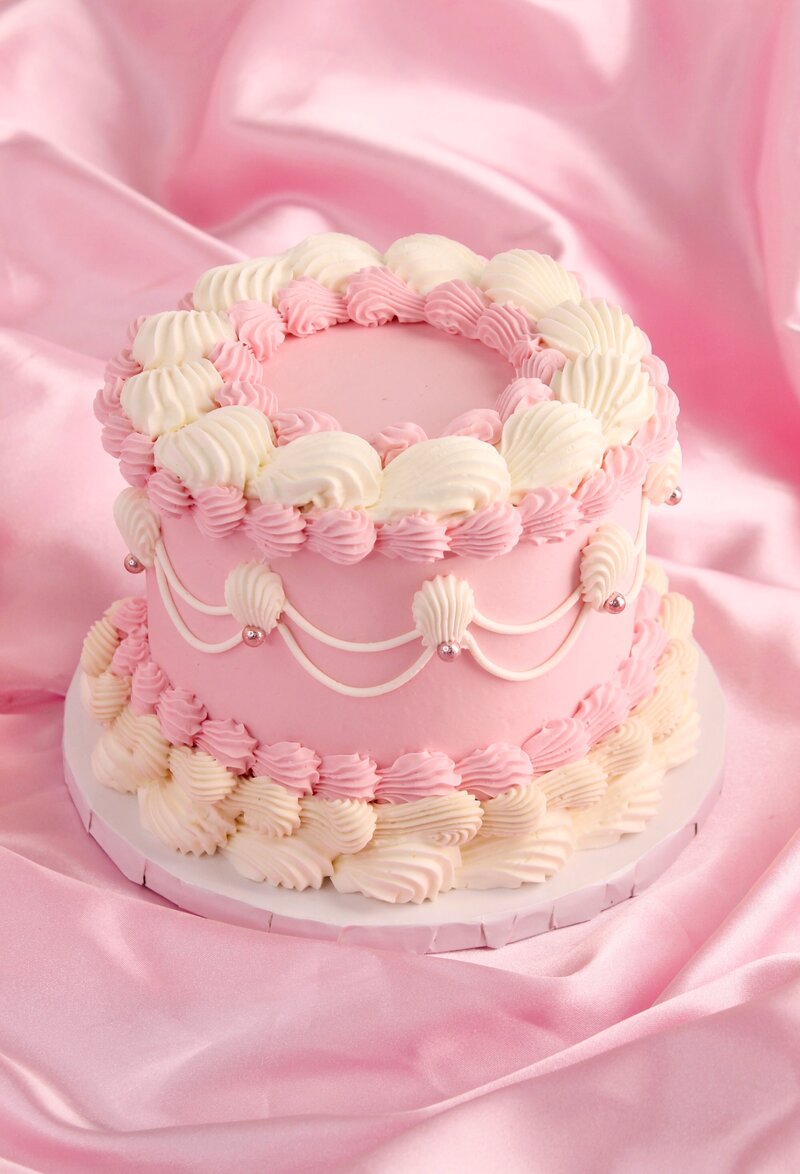 Pink cake with frosting and gold butterflies