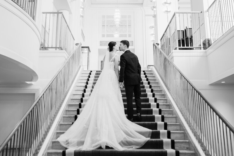Bride and groom kiss on the stair case at The Peninsula Hotel in Chicago