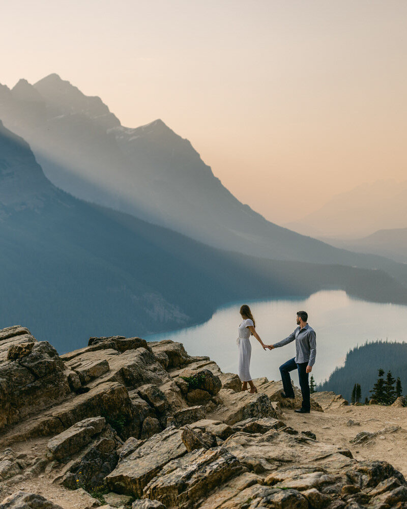 This beautiful engagement photograph captures the bride and groom walking hand in hand at Peyto Lake during a warm summer evening. The soft glow of the sunset enhances the romance of the moment, creating a stunning and serene scene against the lake’s breathtaking backdrop.